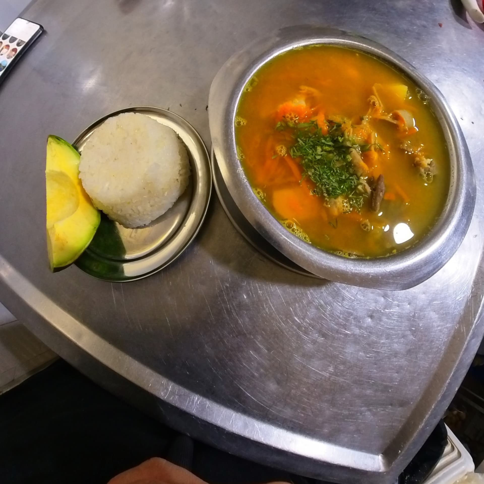 Sancocho de gallina servido con arroz y aguacate