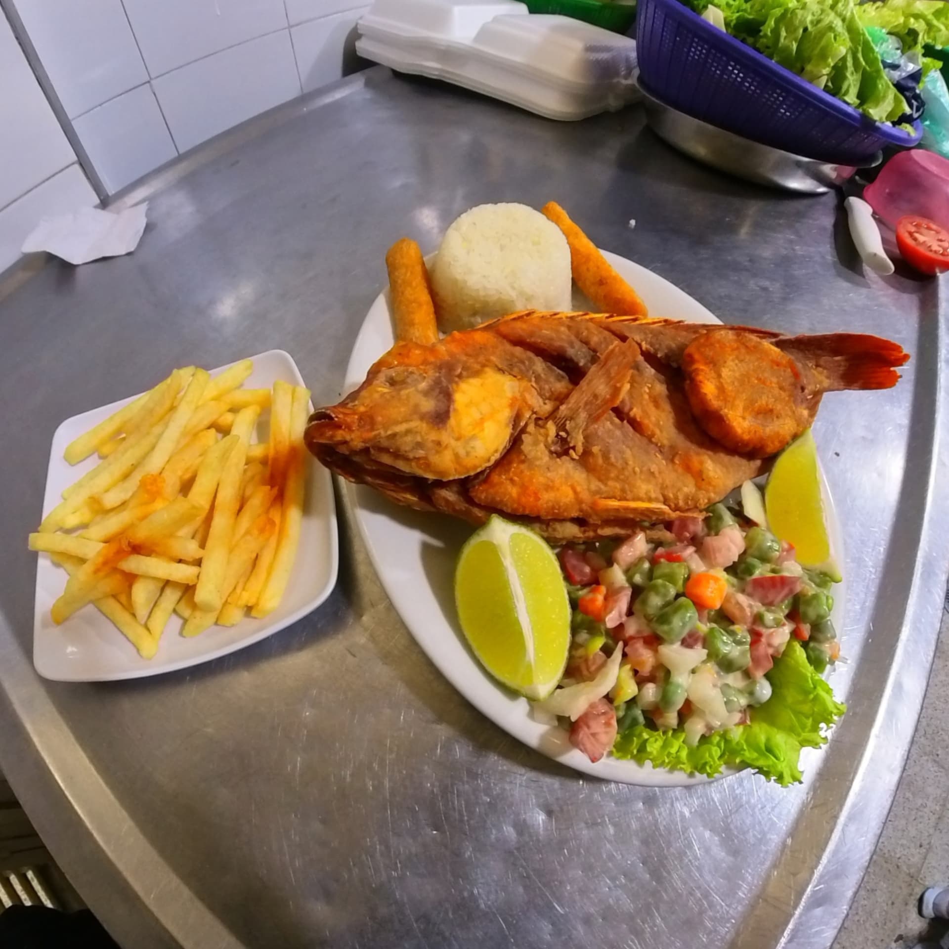 Mojarra frita entera con arroz, papas fritas, patacón y limón